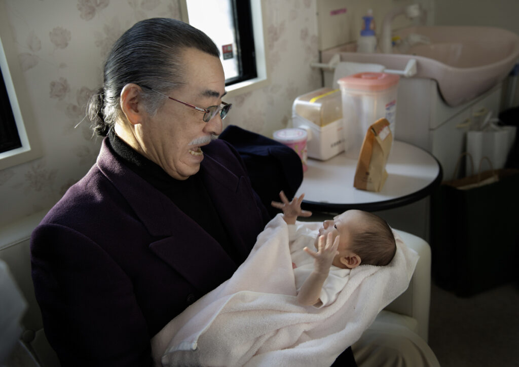 「初対面」おじいさんと生まれたばかりの孫との初対面